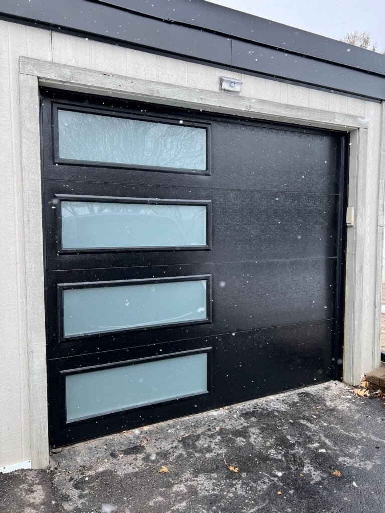 black garage door with 4 glass inserts